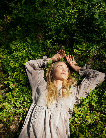 Kvinde liggende i græsset iklædt Claire Woman.